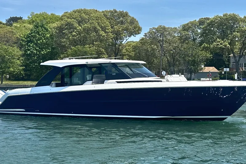 The Image of 2027 Tiara Yachts 56 LS luxury boat on water, surrounded by trees. - 0
