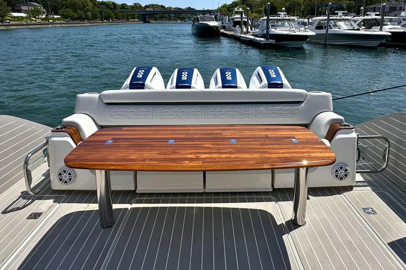 Slide: The Image of 2027 Tiara Yachts 56 LS with wooden table and outboard engines docked by the water. - 11