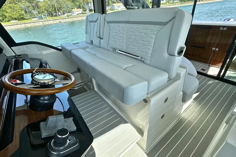 Slide: The Image of Luxurious interior of 2027 Tiara Yachts 56 LS with elegant seating and wooden steering wheel. - 27
