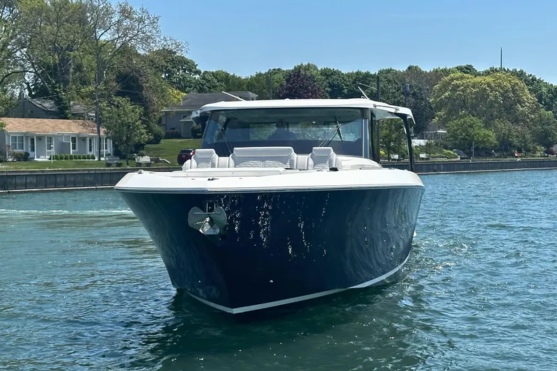 Slide: The Image of 2027 Tiara Yachts 56 LS cruising on a serene waterway, surrounded by lush greenery. - 3