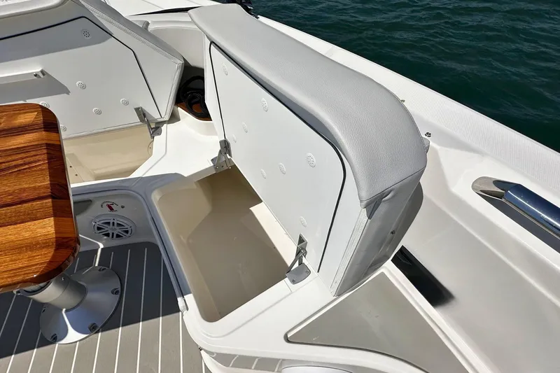 Slide: The Image of 2027 Tiara Yachts 56 LS boat interior with open storage compartment and wooden table. - 34