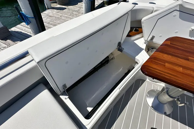 Slide: The Image of Open storage compartment on 2027 Tiara Yachts 56 LS with wooden table nearby. - 35