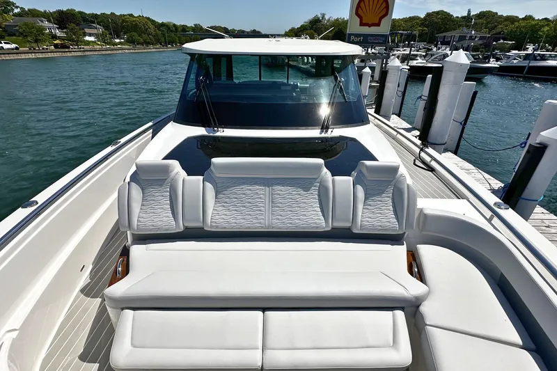 Slide: The Image of 2027 Tiara Yachts 56 LS luxury yacht docked, featuring elegant white seating. - 38