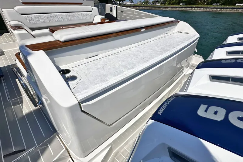 Slide: The Image of Luxury seating and engine area of 2027 Tiara Yachts 56 LS, featuring Mercury engines. - 8