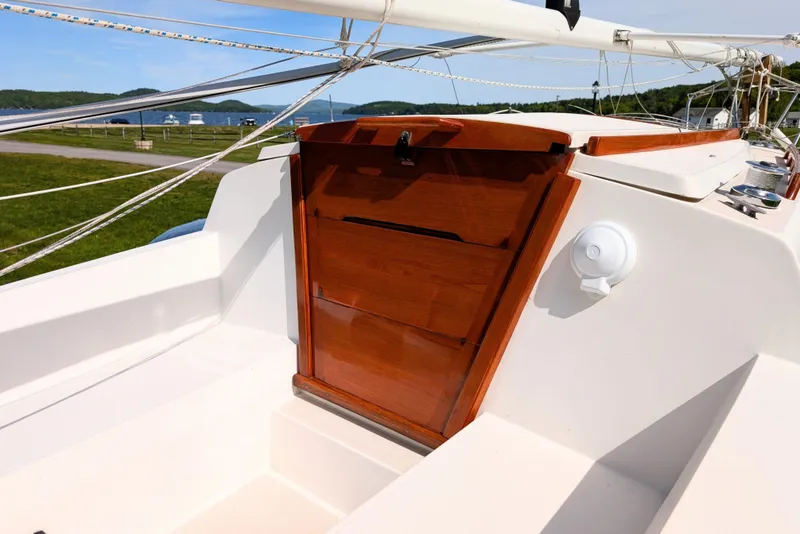 Slide: The Image of 1989 Catalina 22 sailboat cockpit with wooden hatch, rigging, and scenic waterfront view. - 4