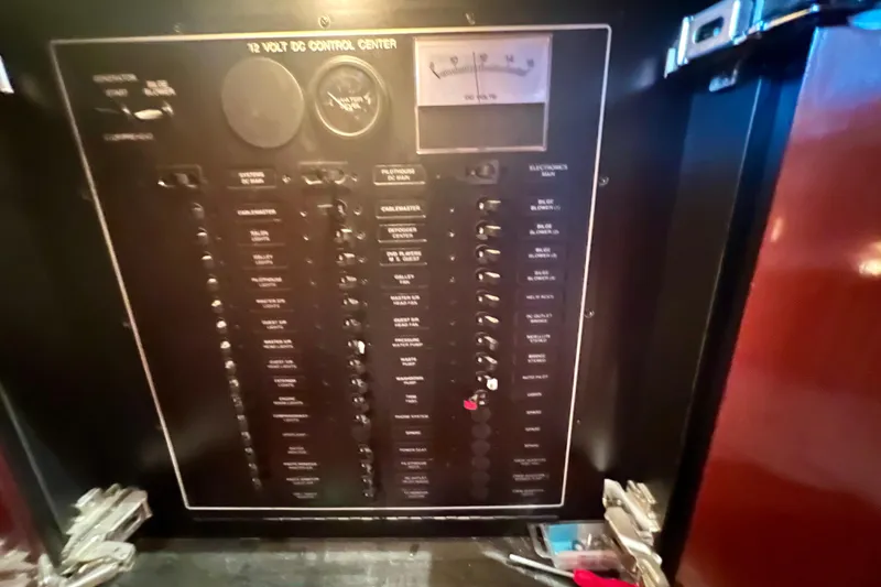 Slide: The Image of Electrical control panel of a 2005 Carver 56 Voyager yacht, featuring various switches and gauges. - 16