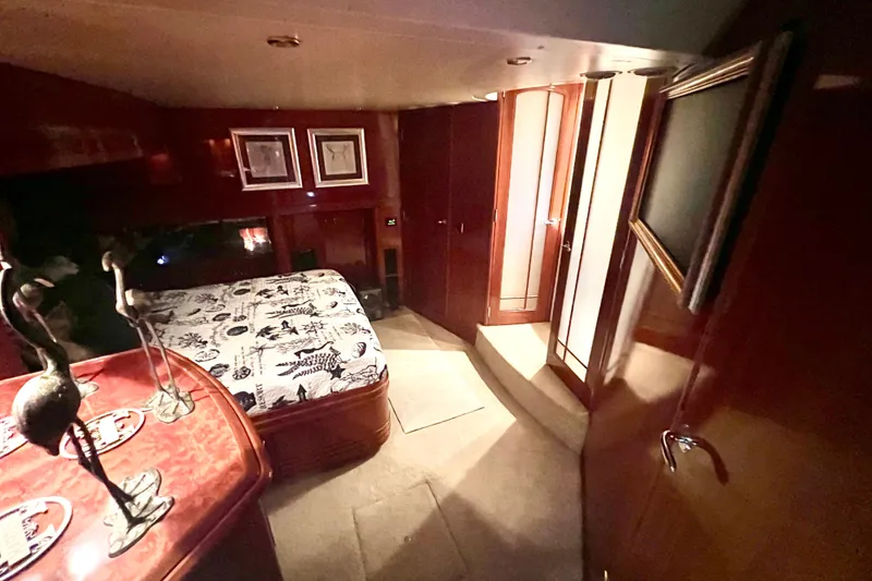 Slide: The Image of Luxurious interior of a 2005 Carver 56 Voyager yacht bedroom with elegant wood finishes. - 25