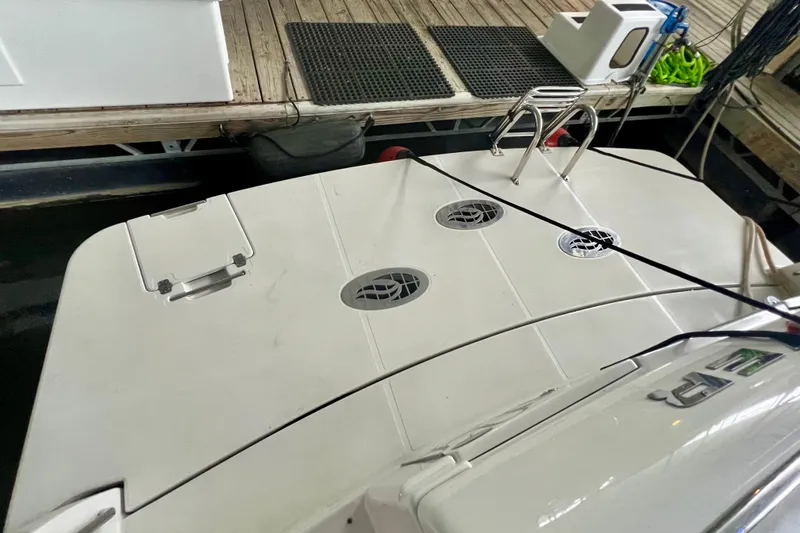 Slide: The Image of 2005 Carver 56 Voyager yacht docked, featuring a spacious swim platform and ladder. - 3