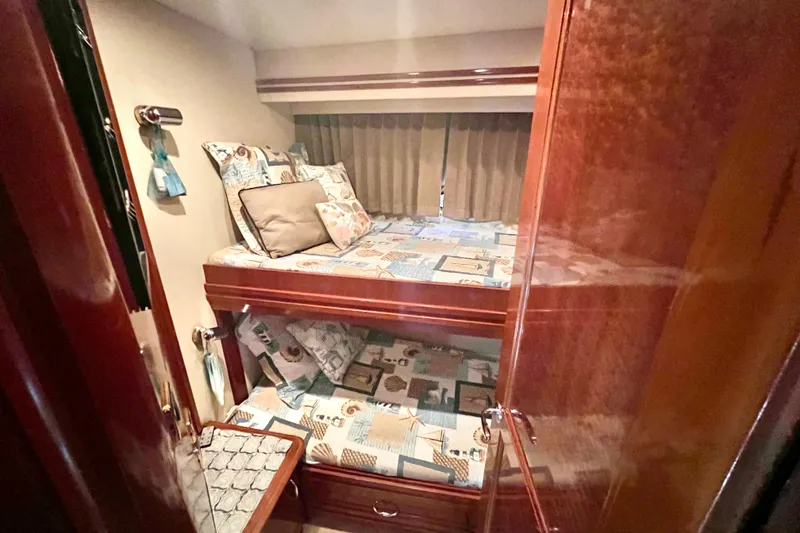 Slide: The Image of Bunk beds in 2005 Carver 56 Voyager yacht cabin with patterned bedding and wooden finishes. - 31