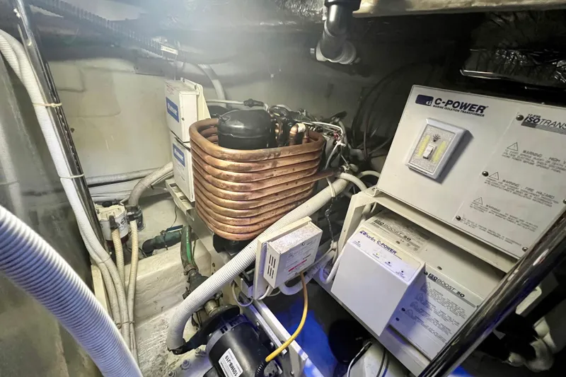 Slide: The Image of Engine room of a 2005 Carver 56 Voyager with electrical components and coiled copper tubing. - 44