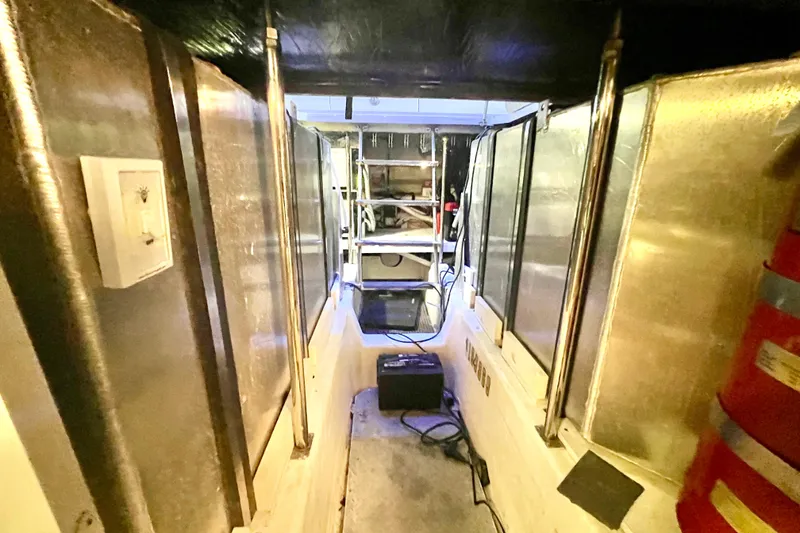 Slide: The Image of Engine room of a 2005 Carver 56 Voyager yacht, featuring metallic surfaces and equipment. - 45