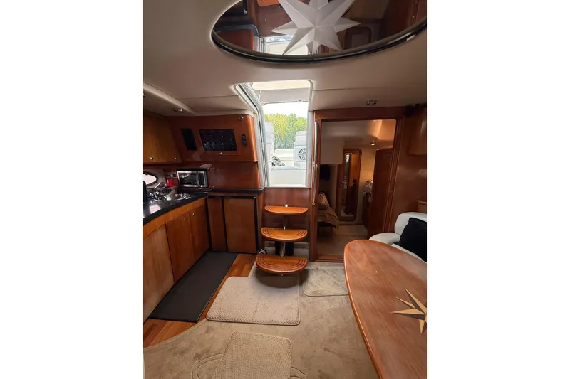Slide: The Image of Interior of 2003 Regal Commodore 4260 yacht with wooden cabinetry and modern amenities. - 15