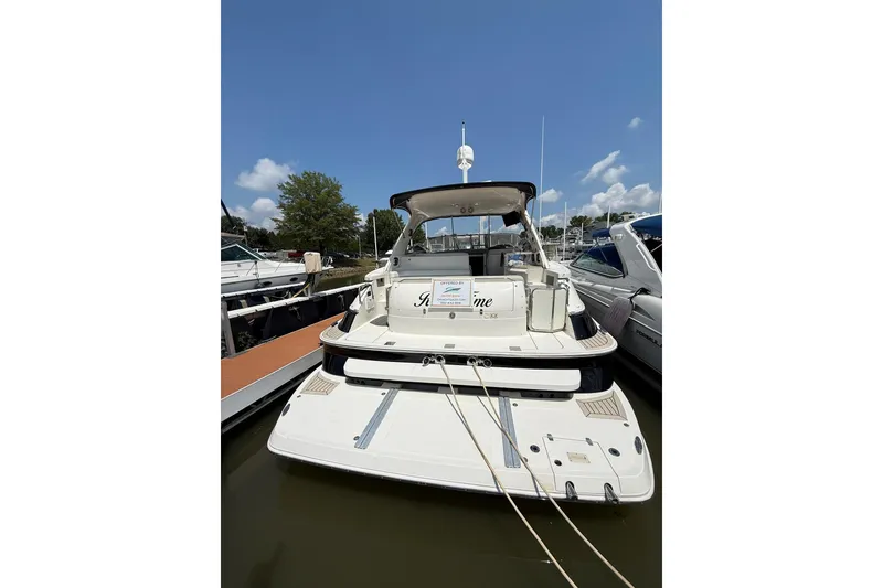 Slide: The Image of 2003 Regal Commodore 4260 yacht docked at marina under clear blue sky. - 16