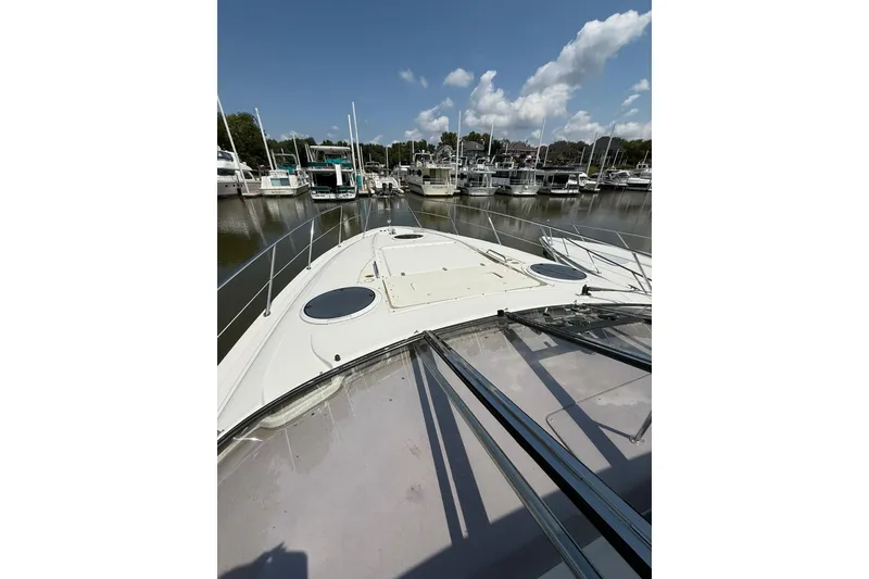 Slide: The Image of 2003 Regal Commodore 4260 yacht docked at marina under clear blue sky. - 6