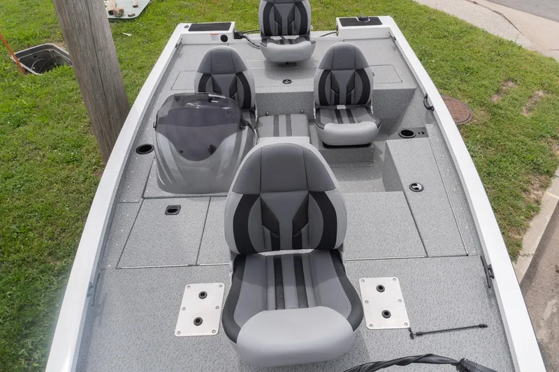 Slide: The Image of 2026 G3 Sportsman 1610 boat interior with gray seating and console, parked on grass. - 11