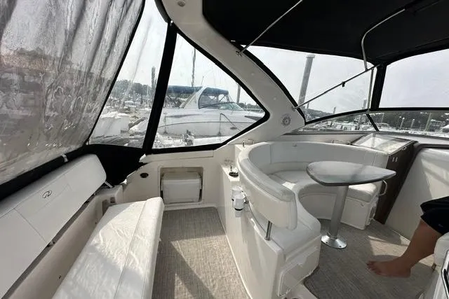 Slide: The Image of 2005 Regal 3360 Window Express yacht interior with seating and table, docked at marina. - 12
