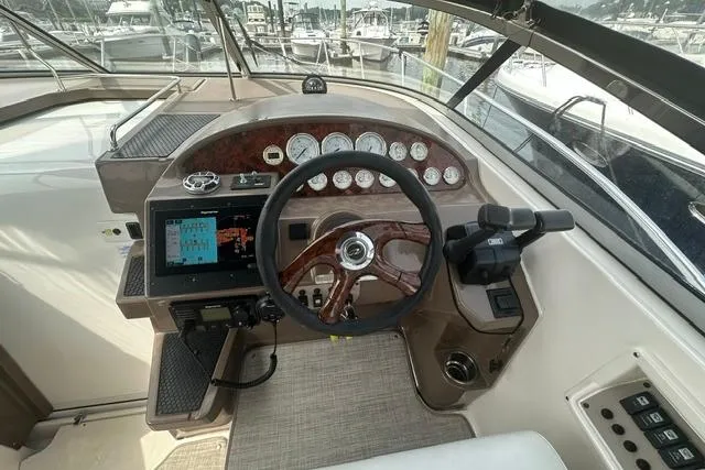 Slide: The Image of 2005 Regal 3360 Window Express boat dashboard with steering wheel and navigation controls. - 16