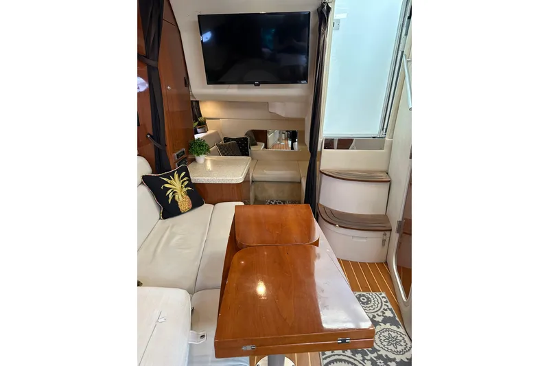 Slide: The Image of Interior of 2005 Regal 3360 Window Express yacht with TV, seating, and wooden table. - 21