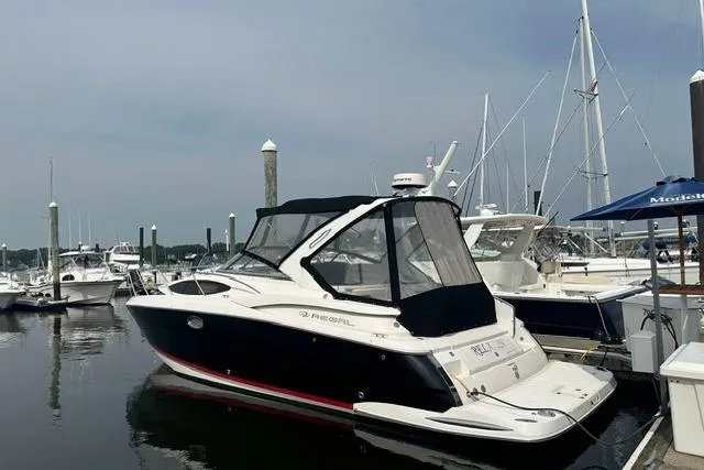 Slide: The Image of 2005 Regal 3360 Window Express boat docked at marina, featuring sleek design and black canopy. - 3