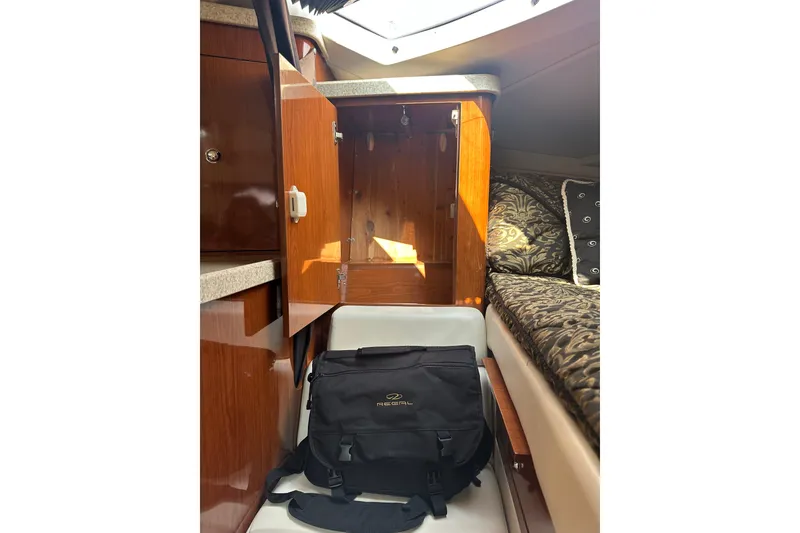 Slide: The Image of 2005 Regal 3360 Window Express cabin interior with open cabinet and patterned bedding. - 31