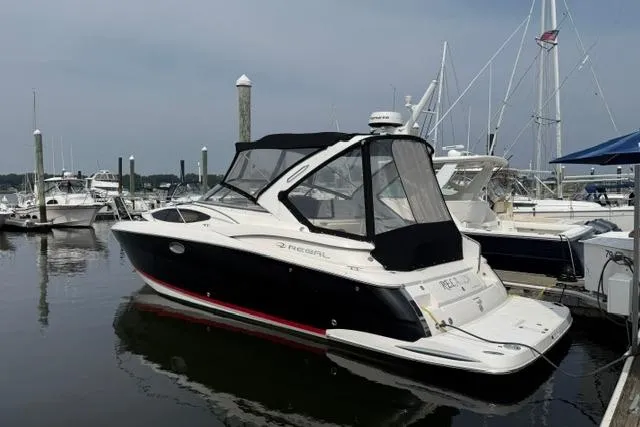 Slide: The Image of 2005 Regal 3360 Window Express boat docked at marina, featuring sleek black and white design. - 5