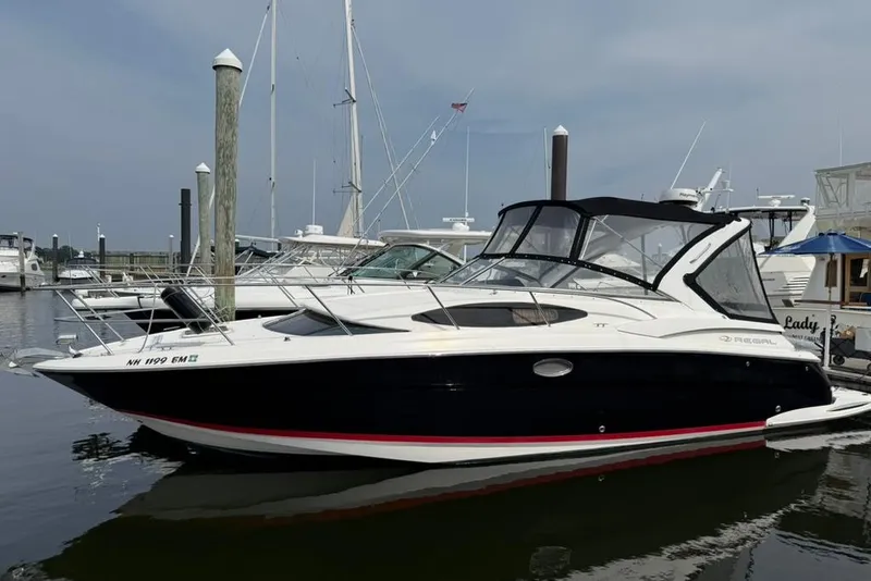 Slide: The Image of 2005 Regal 3360 Window Express boat docked at a marina, featuring sleek design and black hull. - 8