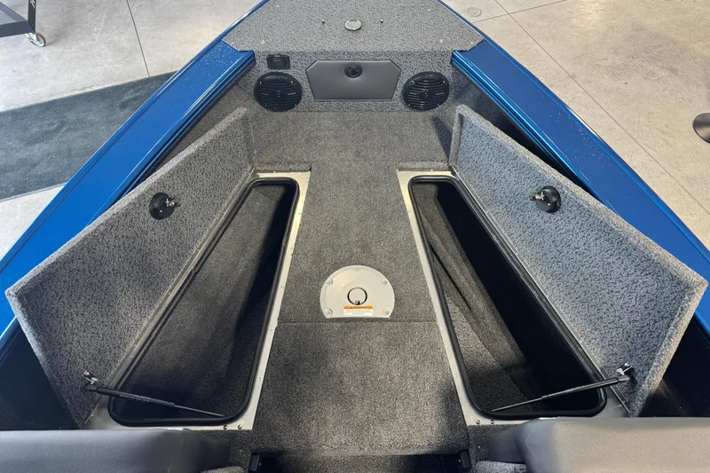 Slide: The Image of 2026 Lund 1875 Crossover XS boat interior with open storage compartments and speakers. - 10