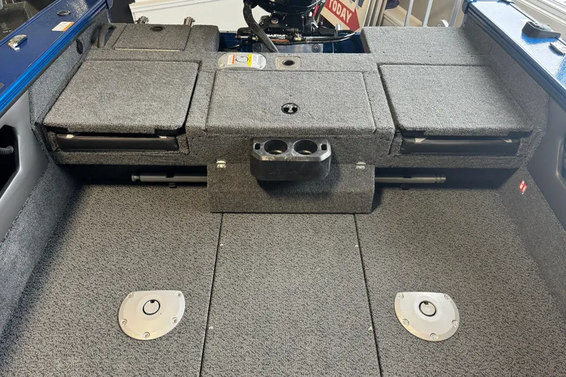 Slide: The Image of Interior view of 2026 Lund 1875 Crossover XS boat, featuring carpeted storage compartments. - 22