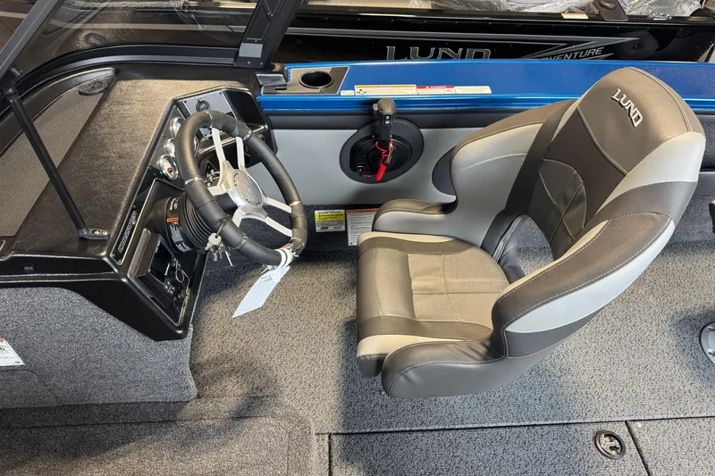 Slide: The Image of 2026 Lund 1875 Crossover XS boat interior with steering wheel and captain's seat. - 5