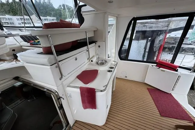 Slide: The Image of 1999 Sea Ray 420 Aft Cabin interior with sink, seating, and wood flooring. - 11