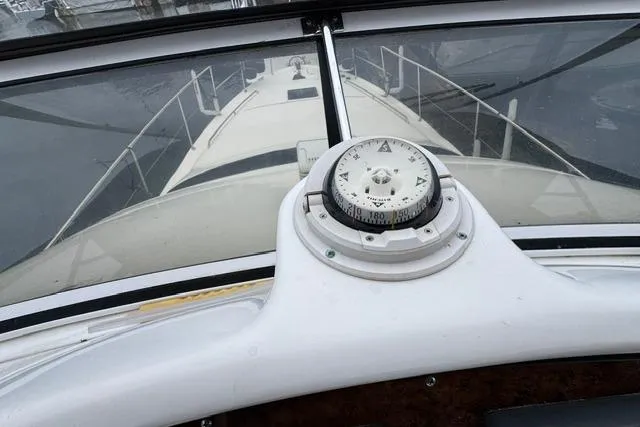 Slide: The Image of 1999 Sea Ray 420 Aft Cabin yacht helm with compass, showcasing sleek design and navigation features. - 22