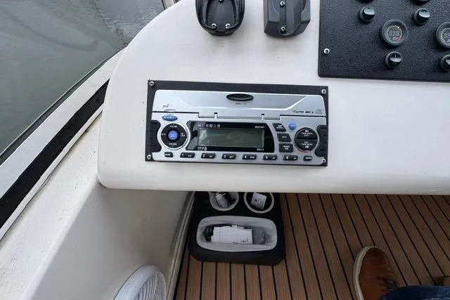 Slide: The Image of 1999 Sea Ray 420 Aft Cabin boat dashboard with stereo system and controls. - 23