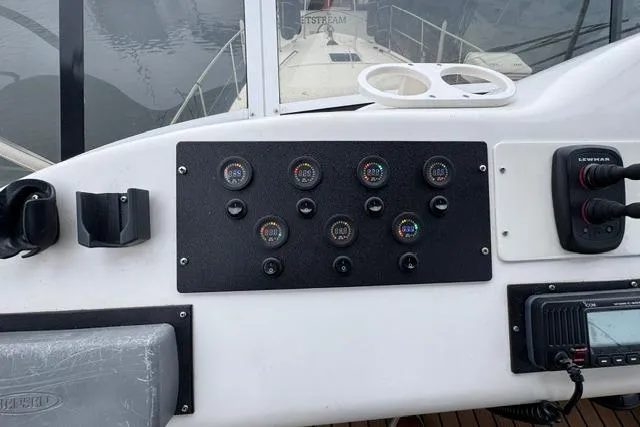 Slide: The Image of 1999 Sea Ray 420 Aft Cabin dashboard with gauges and controls, overlooking the deck. - 24