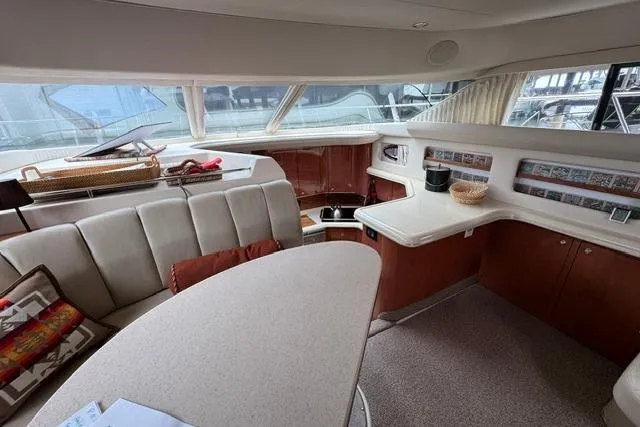 Slide: The Image of Interior of 1999 Sea Ray 420 Aft Cabin yacht with elegant seating and kitchenette. - 29