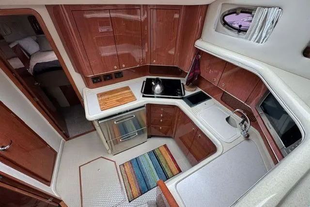 Slide: The Image of Luxurious 1999 Sea Ray 420 Aft Cabin kitchen with modern amenities and elegant wood cabinetry. - 31
