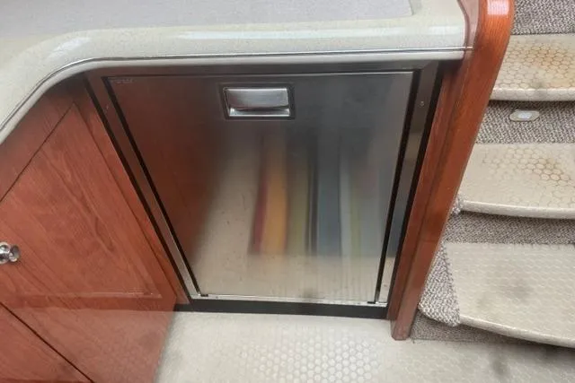 Slide: The Image of Interior of 1999 Sea Ray 420 Aft Cabin with stainless steel fridge and wooden cabinetry. - 33