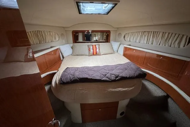 Slide: The Image of Luxurious 1999 Sea Ray 420 Aft Cabin bedroom with cozy bed and elegant wood cabinetry. - 38