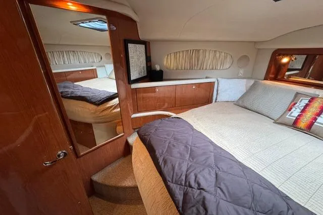 Slide: The Image of Luxurious 1999 Sea Ray 420 Aft Cabin bedroom with elegant wood finishes and cozy bedding. - 39