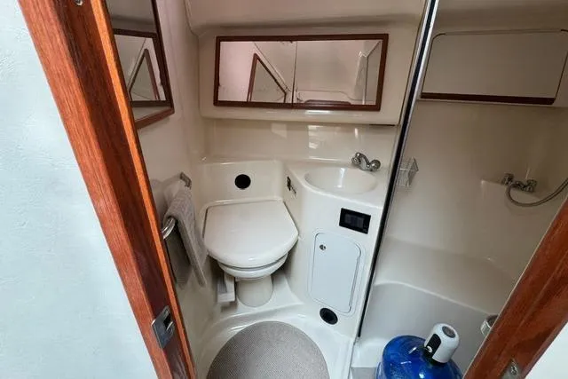 Slide: The Image of 1999 Sea Ray 420 Aft Cabin bathroom with toilet, sink, and shower area. - 41