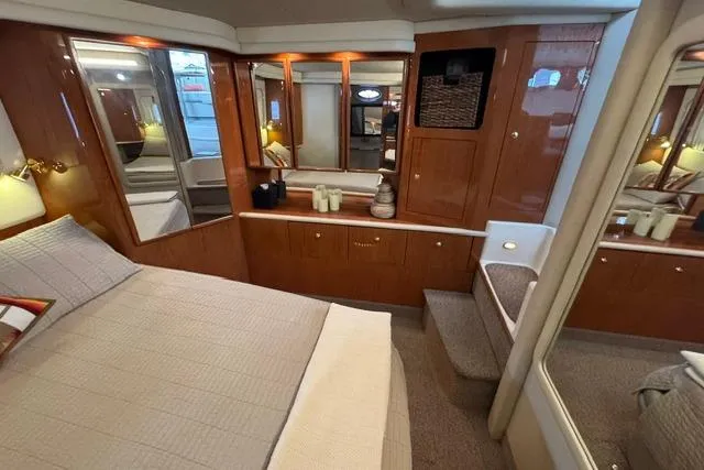 Slide: The Image of Luxurious 1999 Sea Ray 420 Aft Cabin bedroom with elegant wood finishes and cozy bedding. - 43