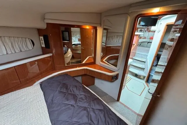 Slide: The Image of Luxurious 1999 Sea Ray 420 Aft Cabin interior with elegant wood finishes and cozy bedding. - 44