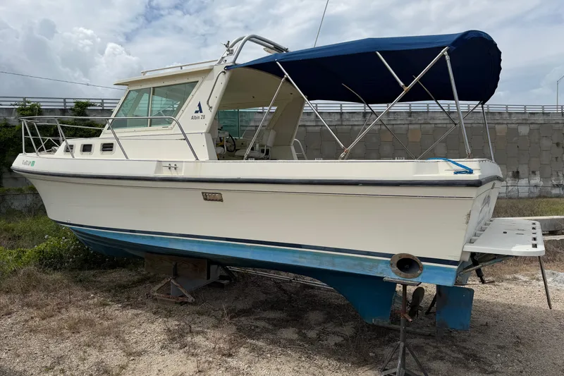 The Image of 2000 Albin 28 Tournament Express boat with blue canopy, parked on dry land. - 0