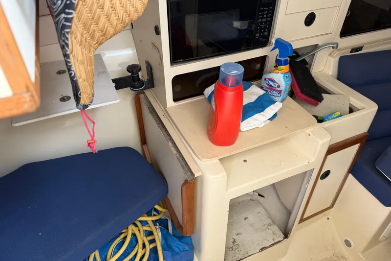 Slide: The Image of Interior of a 2000 Albin 28 Tournament Express with cleaning supplies and storage compartments. - 12