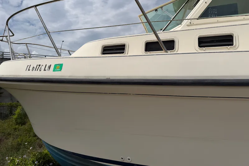 Slide: The Image of 2000 Albin 28 Tournament Express boat with Florida registration, docked under a cloudy sky. - 14