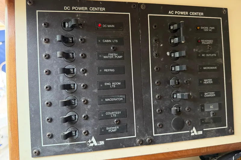 Slide: The Image of Electrical panel of a 2000 Albin 28 Tournament Express boat, showing DC and AC power controls. - 19