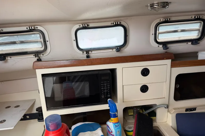 Slide: The Image of Interior of a 2000 Albin 28 Tournament Express with microwave and storage cabinets. - 20