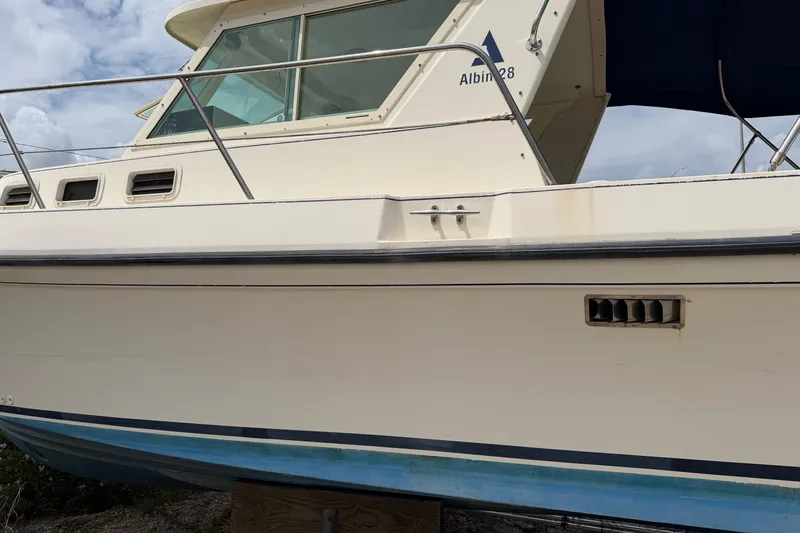 Slide: The Image of 2000 Albin 28 Tournament Express boat with white hull and blue trim, docked outdoors. - 22