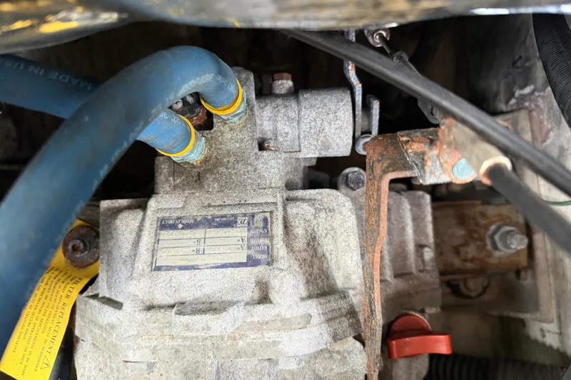 Slide: The Image of Engine component of a 2000 Albin 28 Tournament Express with blue hoses and rusted metal parts. - 32