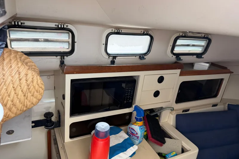Slide: The Image of Interior of a 2000 Albin 28 Tournament Express boat with kitchen area and cleaning supplies. - 38