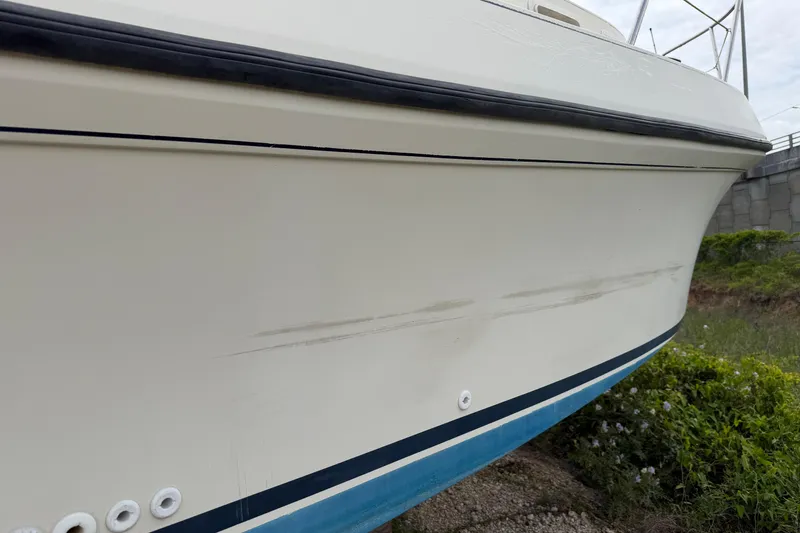 Slide: The Image of 2000 Albin 28 Tournament Express boat hull with visible scuff marks and blue trim. - 40
